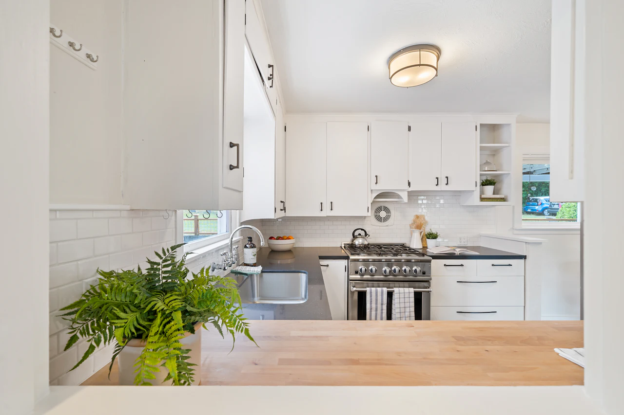 Butcher block wood countertop in a bright white kitchen