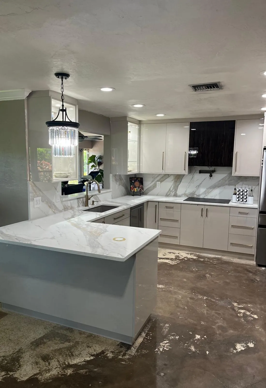 White high-gloss kitchen with a veined countertop and full-height backsplash